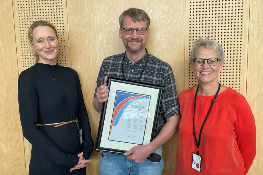 En gruppe mennesker som holder et innrammet bilde