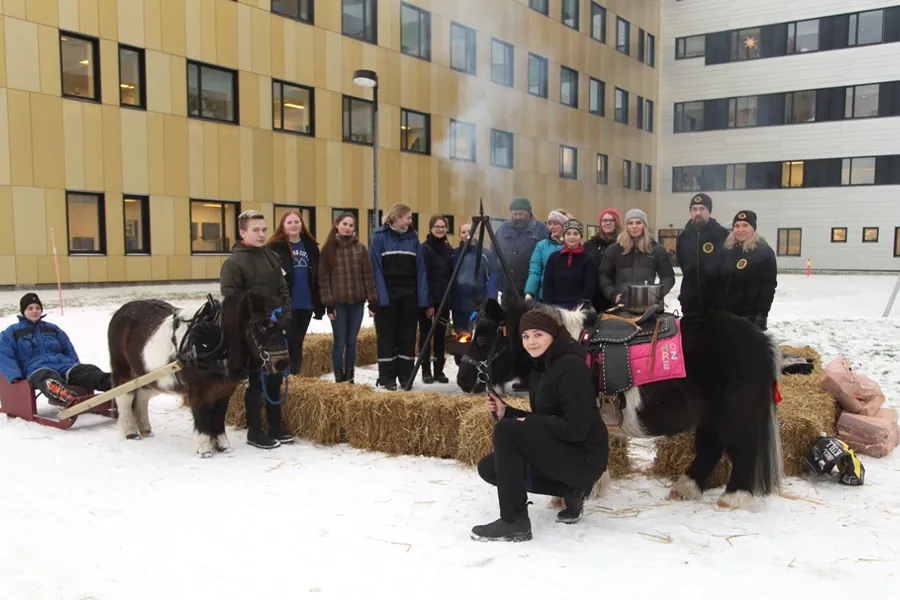 En gruppe mennesker som poserer for et bilde med noen hester