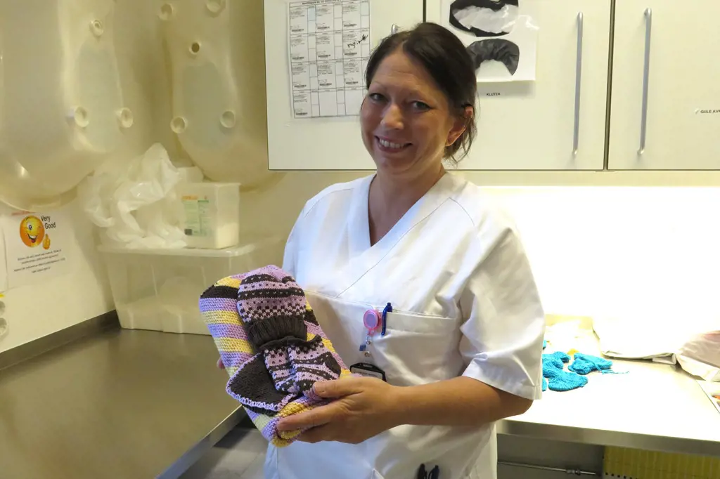 Spesialsykepleier Mona Homstvedt ved nyfødtintensiven i Sykehuset Østfold tar imot klærne fra Amandaprosjektet, og hjelper til m