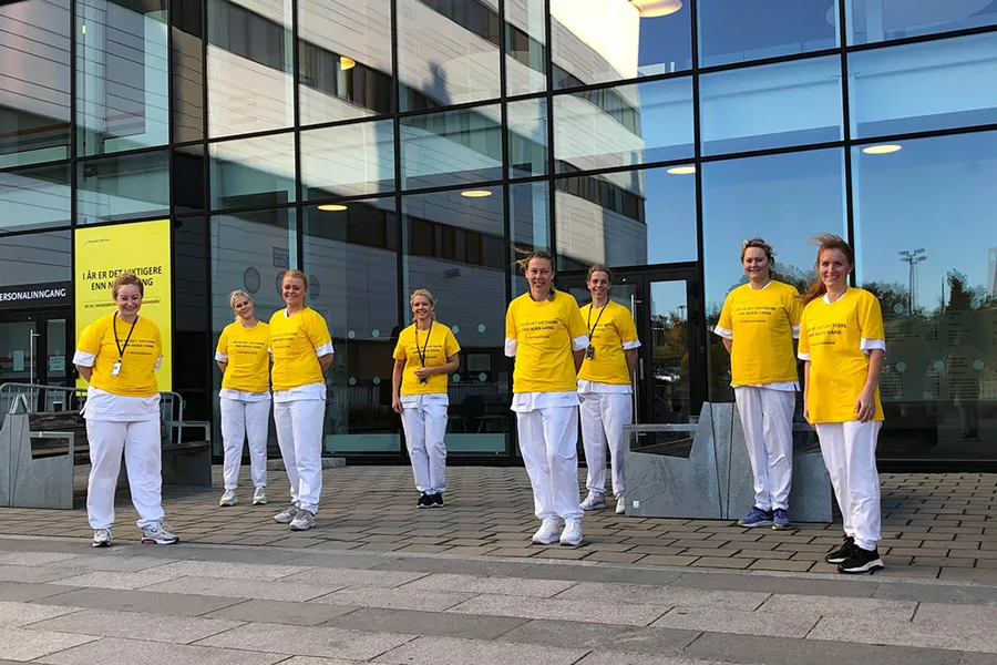 En gruppe mennesker iført matchende gule T-skjorter