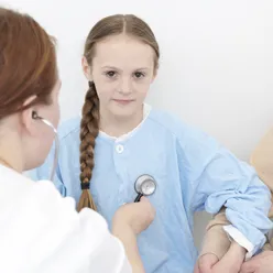 Lege lytter på jente med stetoskop