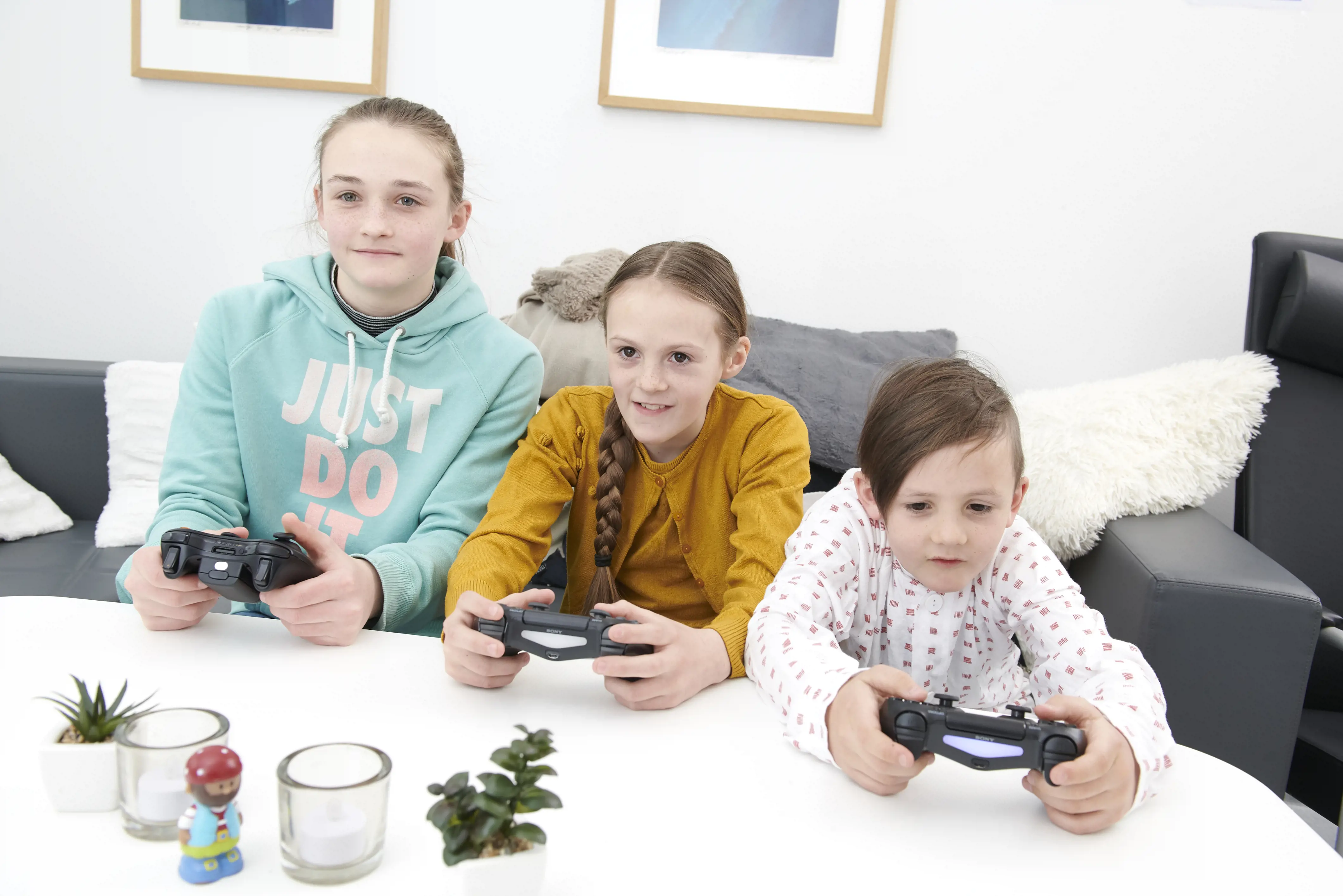 To jenter og en gutt spiller TV-spill