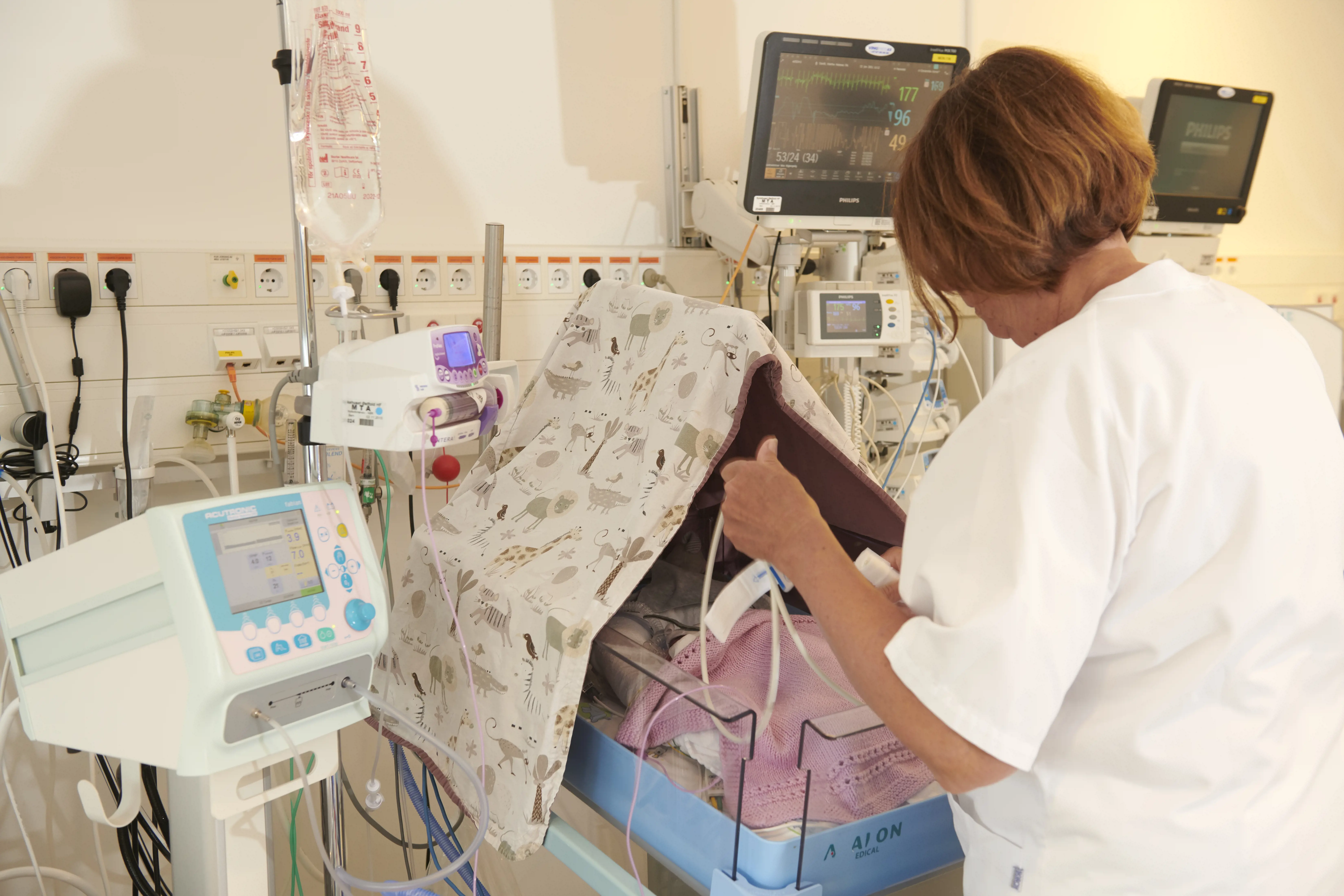 Sykepleier på nyfødtintensiv foran en babyseng