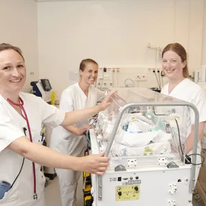 Lege og sykepleiere med baby i kuvøse